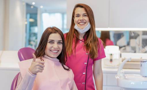 Two women smiling in a dental clinic.