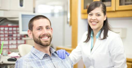 male smiling with ethnic female dental hygienist