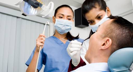 Dentist and dental hygienist performing procedure on patient